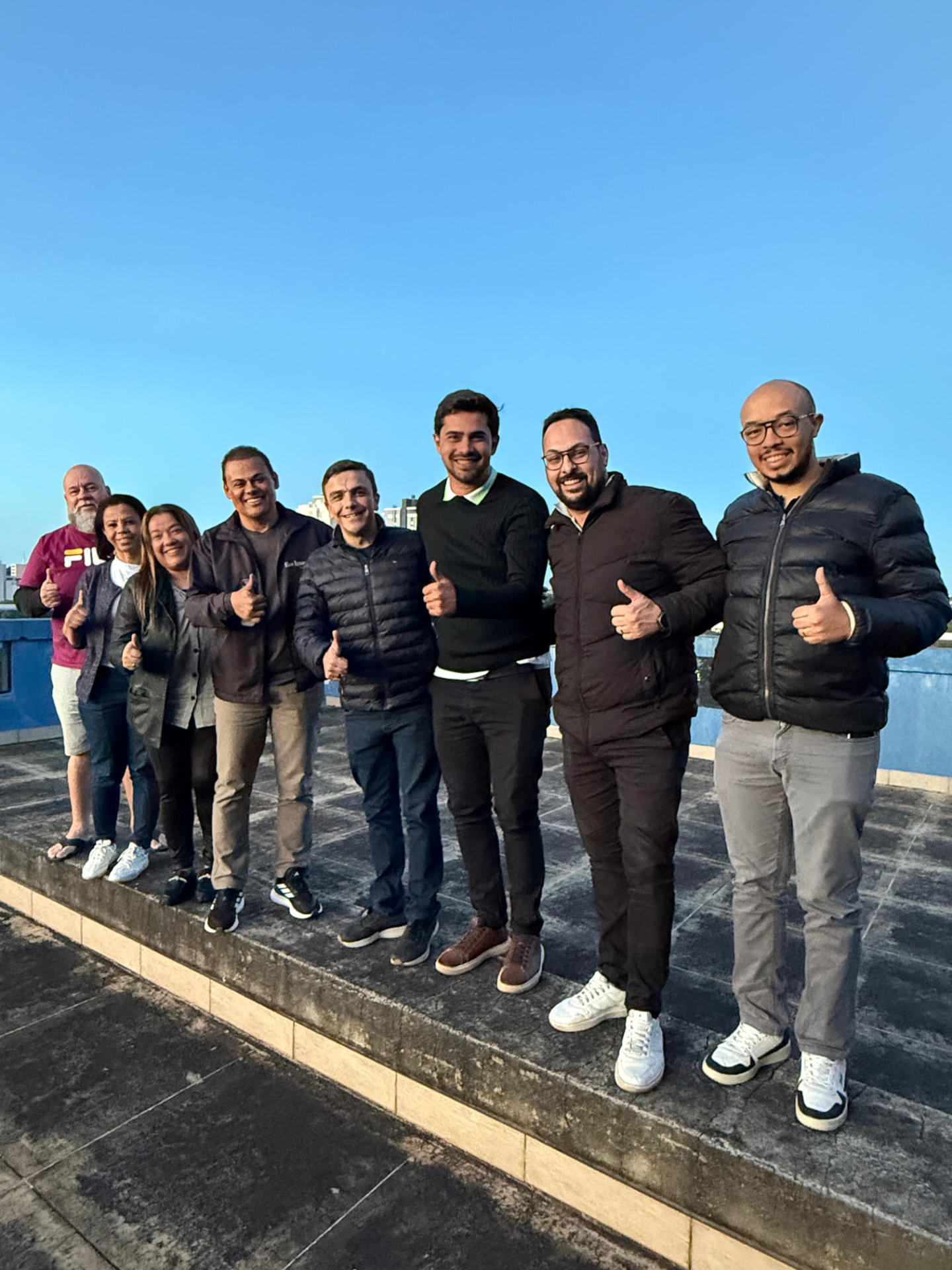 Equipe da ABRACE reunida em um encontro, com polegares para cima